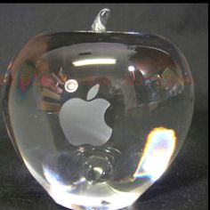 an apple shaped glass object sitting on top of a table