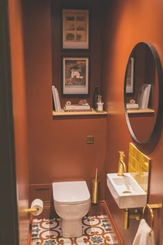 a bathroom with a toilet, sink and mirror on the wall next to each other