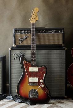 an electric guitar sitting next to two amps