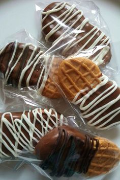 four chocolate covered cookies wrapped in plastic wrappers