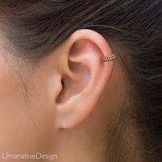 a woman's ear is shown with a gold ring