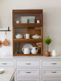 the shelves in the kitchen are filled with dishes and utensils, including one potted plant