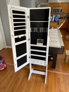 an open cabinet with many drawers on top of it in the middle of a wooden floor