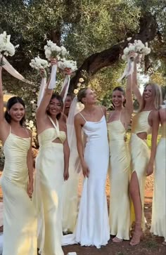 a group of women standing next to each other holding bouquets in front of them