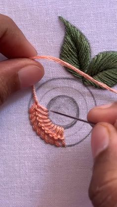 someone is working on something with some thread and scissors in their hands, while they are stitching together