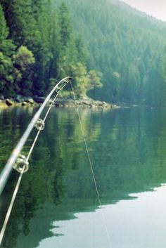 a fishing rod is attached to the side of a boat on a body of water