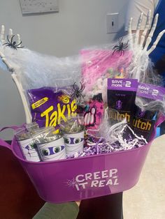 a purple bucket filled with candy and treats