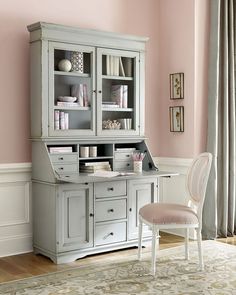 a blue desk and chair in a room with pink walls, rugs and curtains