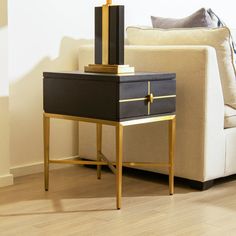 a black and gold end table with a lamp on top