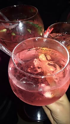 two glasses filled with pink liquid sitting on top of a black table next to each other