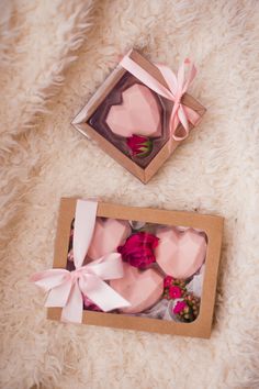 two boxes that have flowers in them on a white carpet with pink ribbon and bows