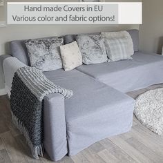 a grey couch sitting on top of a hard wood floor next to a white rug