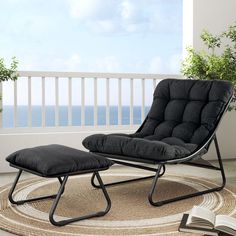 a chair and ottoman on a rug in front of a balcony