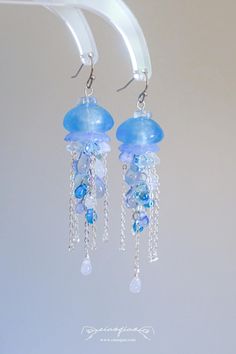 a pair of earrings with blue beads hanging from them