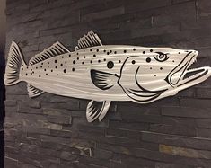 a fish is painted on the side of a brick wall