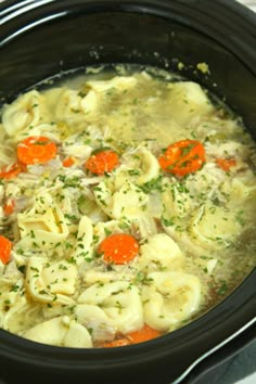 a crock pot filled with dumplings and carrots