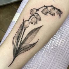 a tattoo with flowers on the arm and one flower is blooming from behind it