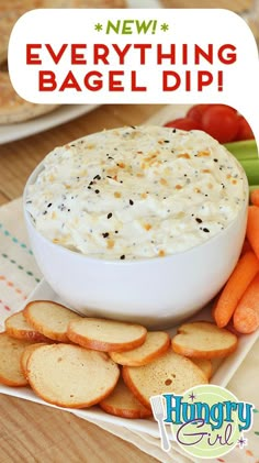 a bowl of dip surrounded by crackers and carrots on a plate with the words, everything bagel dip