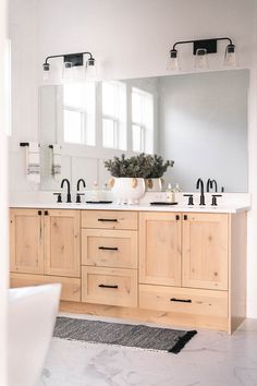 a bathroom with double sinks and large mirrors