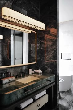 a bathroom with marble counter tops and black walls