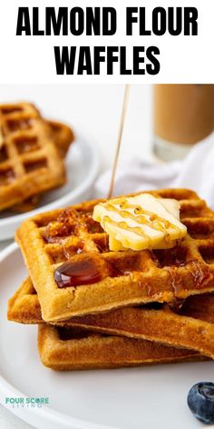 some waffles are stacked on top of each other with blueberries and syrup