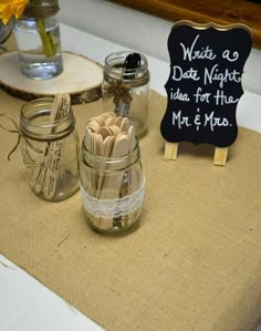 mason jars filled with wooden utensils sitting on top of a table