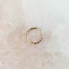 a gold ring sitting on top of a white surface