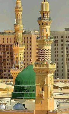 a tall yellow building with a green dome on it's roof and other buildings in the background