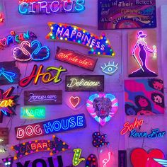 many neon signs are displayed on the wall