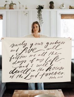 a woman holding up a sign with writing on it