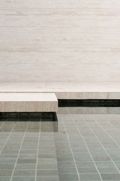 a white bench sitting on top of a tiled floor