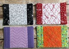 four quilted placemats sitting on top of a wooden table