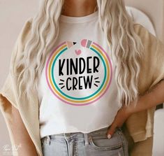 a woman wearing a t - shirt with the words kinder crew printed on it