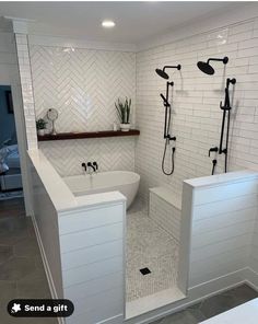 a bathroom with white tiles and black fixtures on the walls, along with a walk in shower