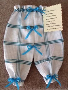 two baby swaddles with blue bows on the bottom and one has a note attached to it