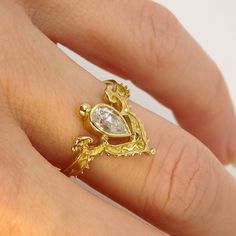 a woman's hand with a gold ring on it and a diamond in the middle