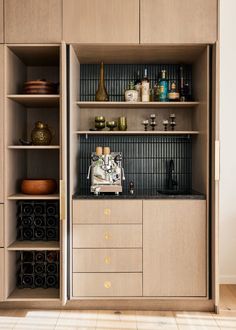 a kitchen with wooden cabinets and shelves filled with wine bottles on top of counter tops