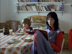 two people sitting at a table with food