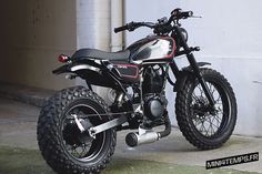 a black and red motorcycle parked next to a building