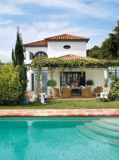 a house with a pool in front of it and an outdoor dining area next to it