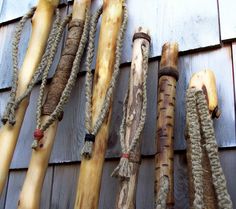 there are many different types of sticks hanging on the side of a building with ropes attached to them