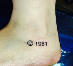 a person with a small tattoo on their foot that reads, date 1911 and the number thirteen