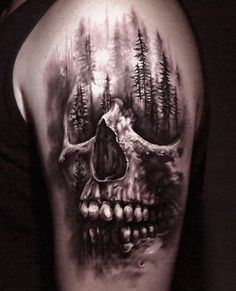 a man's arm with a skull and trees on it