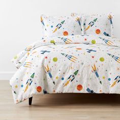 an image of a bed with space themed sheets