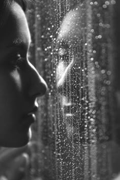 a woman looking out the window with rain drops on it