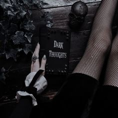 a woman's legs with black stockings and white socks on, next to a book