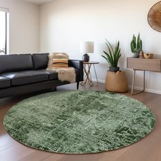 a living room with black leather couches and a green round rug on the floor