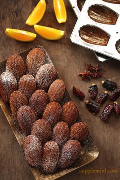 an assortment of pastries on a table with oranges and dried fruit next to them