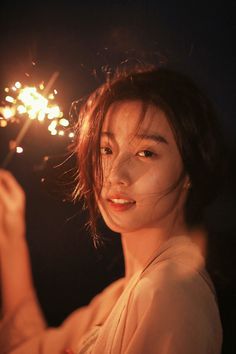 a woman holding a sparkler in her hand