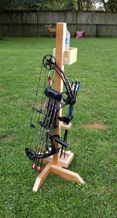 a wooden archery stand with arrows and bows on it